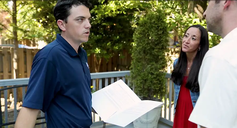 worker talking to homeowners outside